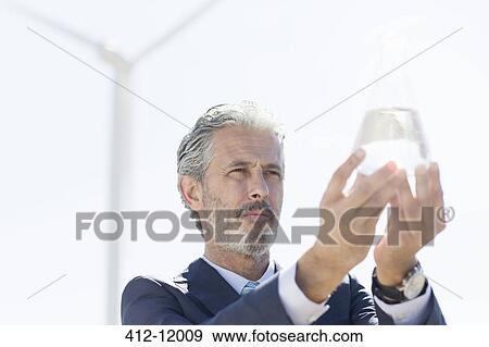 Businessman holding glass of water outdoors View Large Photo Image Stock Photo - Businessman holding glass of water outdoors. Fotosearch
