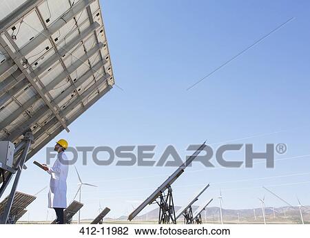 Scientist examining solar panel in rural landscape View Large Photo Image Stock Image - Scientist examining solar panel in rural landscape. Fotosearch