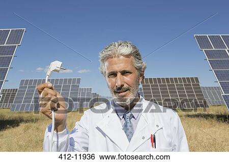 Scientist holding plug to solar panels View Large Photo Image Stock Photograph - Scientist holding plug to solar panels. Fotosearch