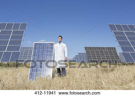 Scientist holding solar panel in rural landscape View Large Photo Image Stock Image - Scientist holding solar panel in rural landscape. Fotosearch