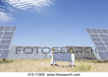 Scientists carrying solar panel in rural landscape View Large Photo Image Stock Photography - Scientists carrying solar panel in rural landscape. Fotosearch