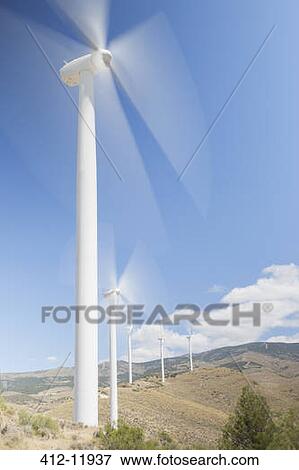 Wind turbines spinning in rural landscape View Large Photo Image Stock Photo - Wind turbines spinning in rural landscape. Fotosearch