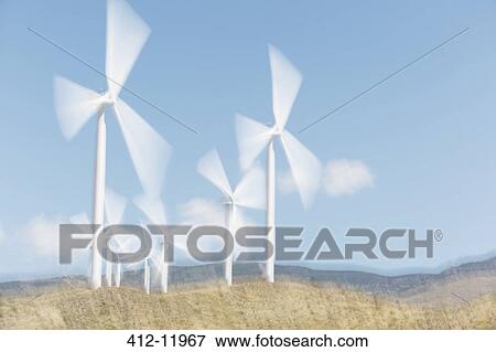 Wind turbines spinning in rural landscape View Large Photo Image Stock Photo - Wind turbines spinning in rural landscape. Fotosearch