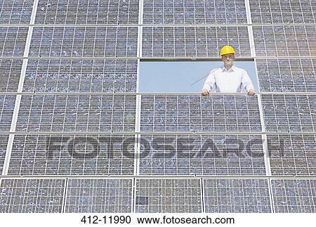 Worker examining solar panel in rural landscape View Large Photo Image Stock Image - Worker examining solar panel in rural landscape. Fotosearch