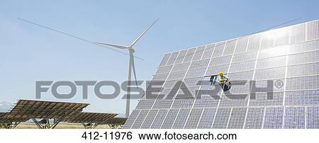 Worker examining solar panel in rural landscape View Large Photo Image Stock Photograph - Worker examining solar panel in rural landscape. Fotosearch