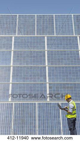 Worker examining solar panels View Large Photo Image Stock Image - Worker examining solar panels. Fotosearch