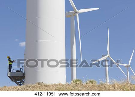 Worker examining wind turbine in rural landscape View Large Photo Image Stock Image - Worker examining wind turbine in rural landscape. Fotosearch