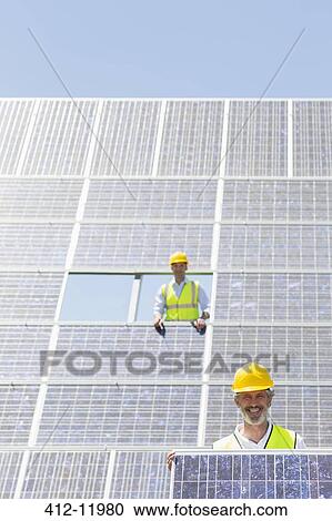 Worker holding solar panel in rural landscape View Large Photo Image Stock Image - Worker holding solar panel in rural landscape. Fotosearch