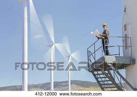 Worker standing on wind turbine in rural landscape View Large Photo Image Stock Image - Worker standing on wind turbine in rural landscape. Fotosearch