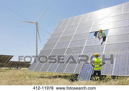 Workers examining solar panel in rural landscape View Large Photo Image Stock Photo - Workers examining solar panel in rural landscape. Fotosearch