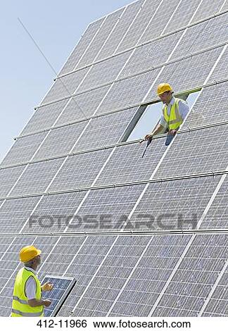 Workers examining solar panels View Large Photo Image Stock Photograph - Workers examining solar panels. Fotosearch