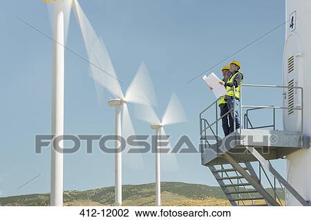 Workers standing on wind turbine in rural landscape View Large Photo Image Stock Image - Workers standing on wind turbine in rural landscape. Fotosearch