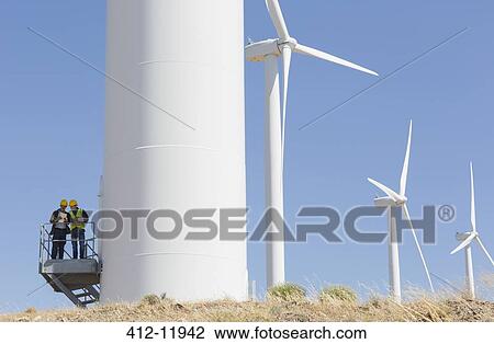 Workers talking on wind turbine in rural landscape View Large Photo Image Stock Image - Workers talking on wind turbine in rural landscape. Fotosearch