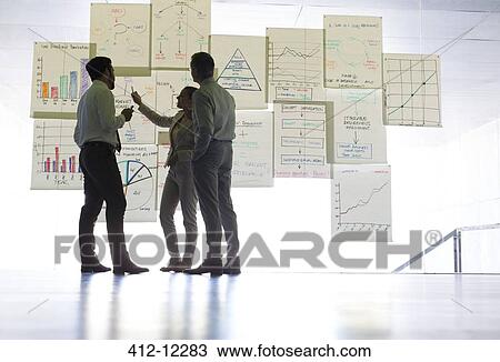 Business people discussing charts and graphs hanging in office View Large Photo Image Stock Image - Business people discussing charts and graphs hanging in office. Fotosearch