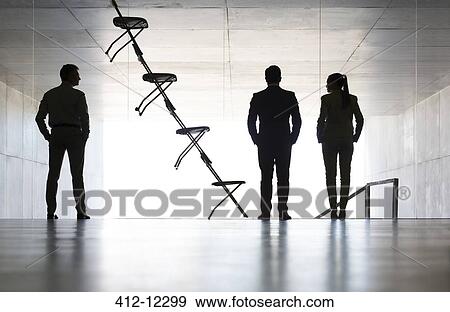 Business people standing next to office chair installation art View Large Photo Image Stock Photo - Business people standing next to office chair installation art. Fotosearch