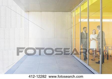 Business people talking at office window View Large Photo Image Stock Image - Business people talking at office window. Fotosearch