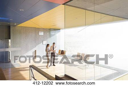 Business people talking in sunny lobby View Large Photo Image Stock Image - Business people talking in sunny lobby. Fotosearch