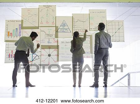 Stock Image - Business people working with charts and graphs on glass wall. Fotosearch