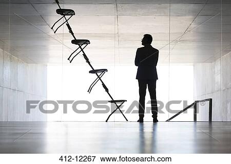 Businessman examining office chair installation art View Large Photo Image Stock Photo - Businessman examining office chair installation art. Fotosearch