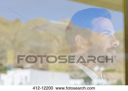 Stock Image - Businessman looking out window. Fotosearch