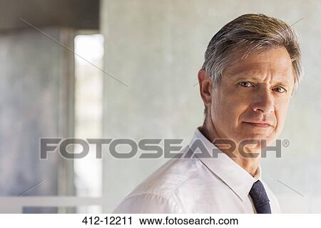 Businessman smiling in office View Large Photo Image Stock Image - Businessman smiling in office. Fotosearch