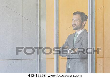 Stock Photo - Businessman standing at office window. Fotosearch