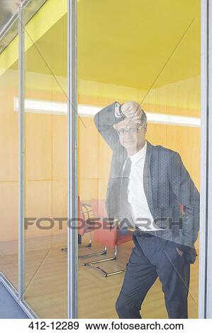 Stock Photo - Businessman standing at office window. Fotosearch