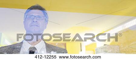 Businessman standing at office window View Large Photo Image Stock Photography - Businessman standing at office window. Fotosearch
