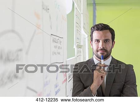 Stock Photography - Businessman thinking at glass wall. Fotosearch