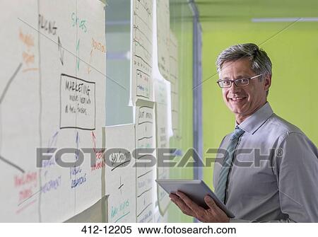 Businessman using digital tablet in office View Large Photo Image Stock Photography - Businessman using digital tablet in office. Fotosearch