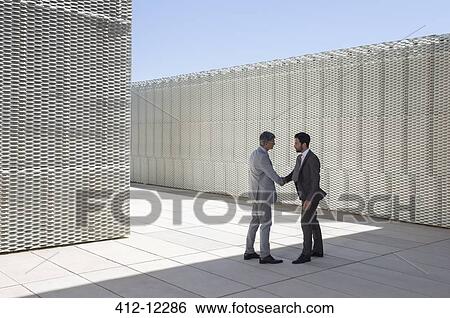 Businessmen shaking hands outdoors View Large Photo Image Stock Photograph - Businessmen shaking hands outdoors. Fotosearch