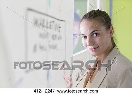 Stock Photo - Businesswoman standing at flow chart on glass wall. Fotosearch