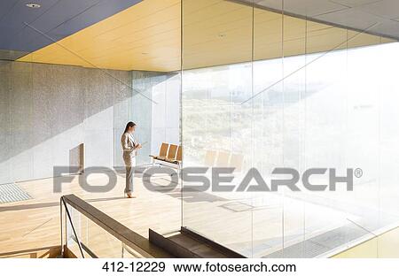 Businesswoman standing in sunny office View Large Photo Image Stock Photo - Businesswoman standing in sunny office. Fotosearch