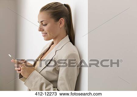 Stock Image - Businesswoman using cell phone. Fotosearch