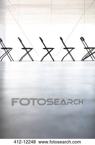 Chairs lined up in a row in office View Large Photo Image Stock Photo - Chairs lined up in a row in office. Fotosearch