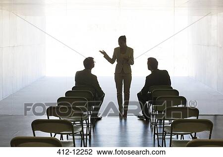 Stock Image - Silhouette of business people talking in office. Fotosearch