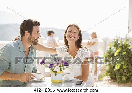 Stock Photography - Couple enjoying coffee on balcony. Fotosearch