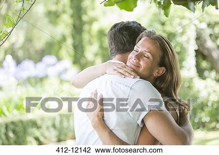 Stock Image - Couple hugging outdoors. Fotosearch