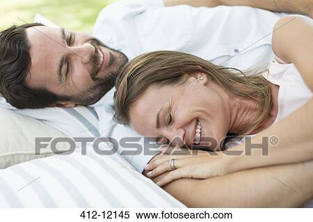 Couple relaxing on blanket outdoors View Large Photo Image Stock Photography - Couple relaxing on blanket outdoors. Fotosearch