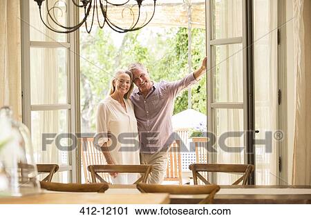 Stock Image - Couple smiling in doorway. Fotosearch
