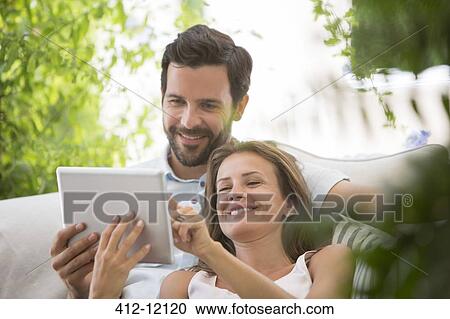 Couple using digital tablet outdoors View Large Photo Image Stock Image - Couple using digital tablet outdoors. Fotosearch