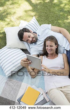 Stock Photo - Couple using digital tablet outdoors. Fotosearch