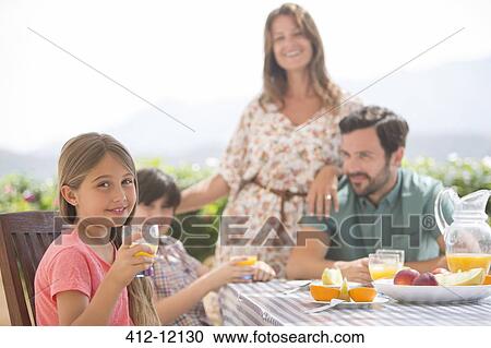 Family eating together at patio table View Large Photo Image Stock Image - Family eating together at patio table. Fotosearch