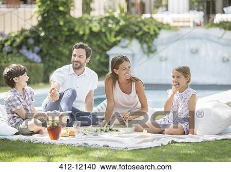 Family enjoying picnic in grass View Large Photo Image Stock Image - Family enjoying picnic in grass. Fotosearch