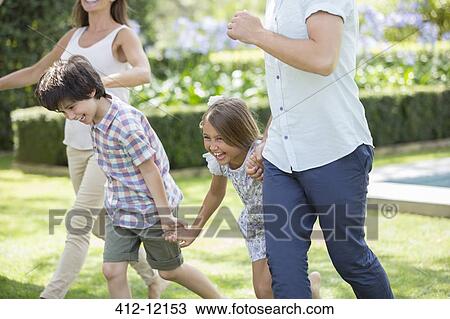 Family holding hands and running in backyard View Large Photo Image Stock Image - Family holding hands and running in backyard. Fotosearch
