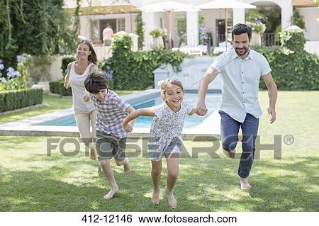 Stock Photograph - Family running together in backyard. Fotosearch