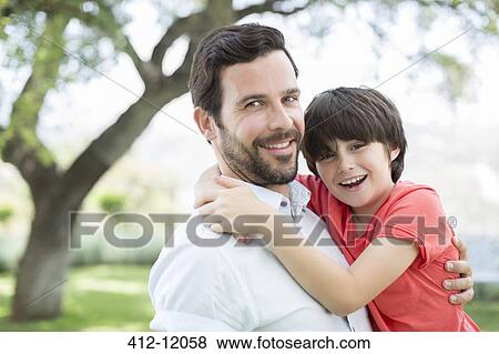 Stock Photo - Father and son smiling outdoors. Fotosearch