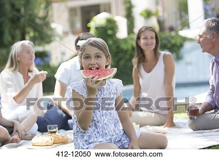 Girl eating watermelon at picnic View Large Photo Image Stock Image - Girl eating watermelon at picnic. Fotosearch