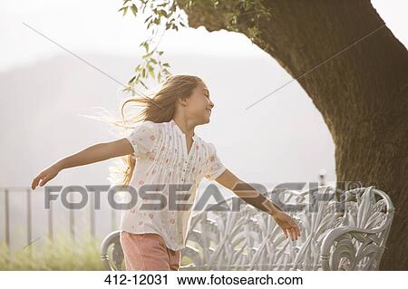 Stock Image - Girl running with arms outstretched. Fotosearch