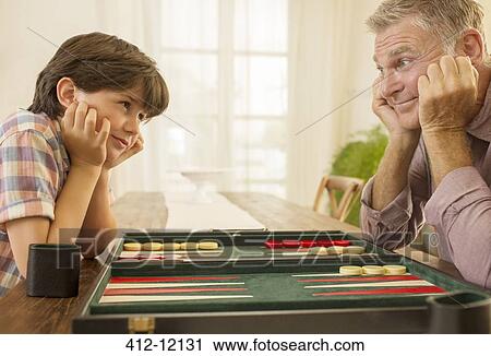 Grandfather and grandson playing backgammon View Large Photo Image Stock Image - Grandfather and grandson playing backgammon. Fotosearch
